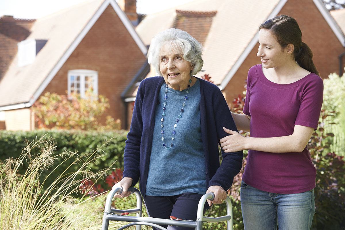 Daughter Helping Senior Mother To Use Walking Frame Daughter Helping Senior Mother To Use Walking Frame